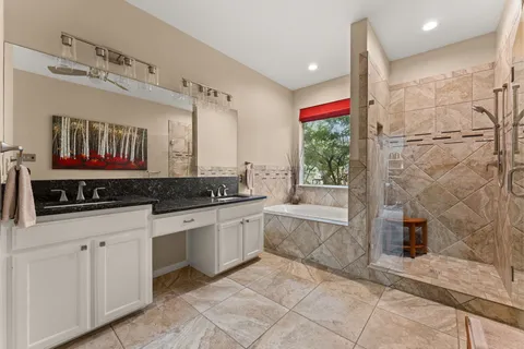 a large bathroom with a granite countertop sink mirror and bathtub