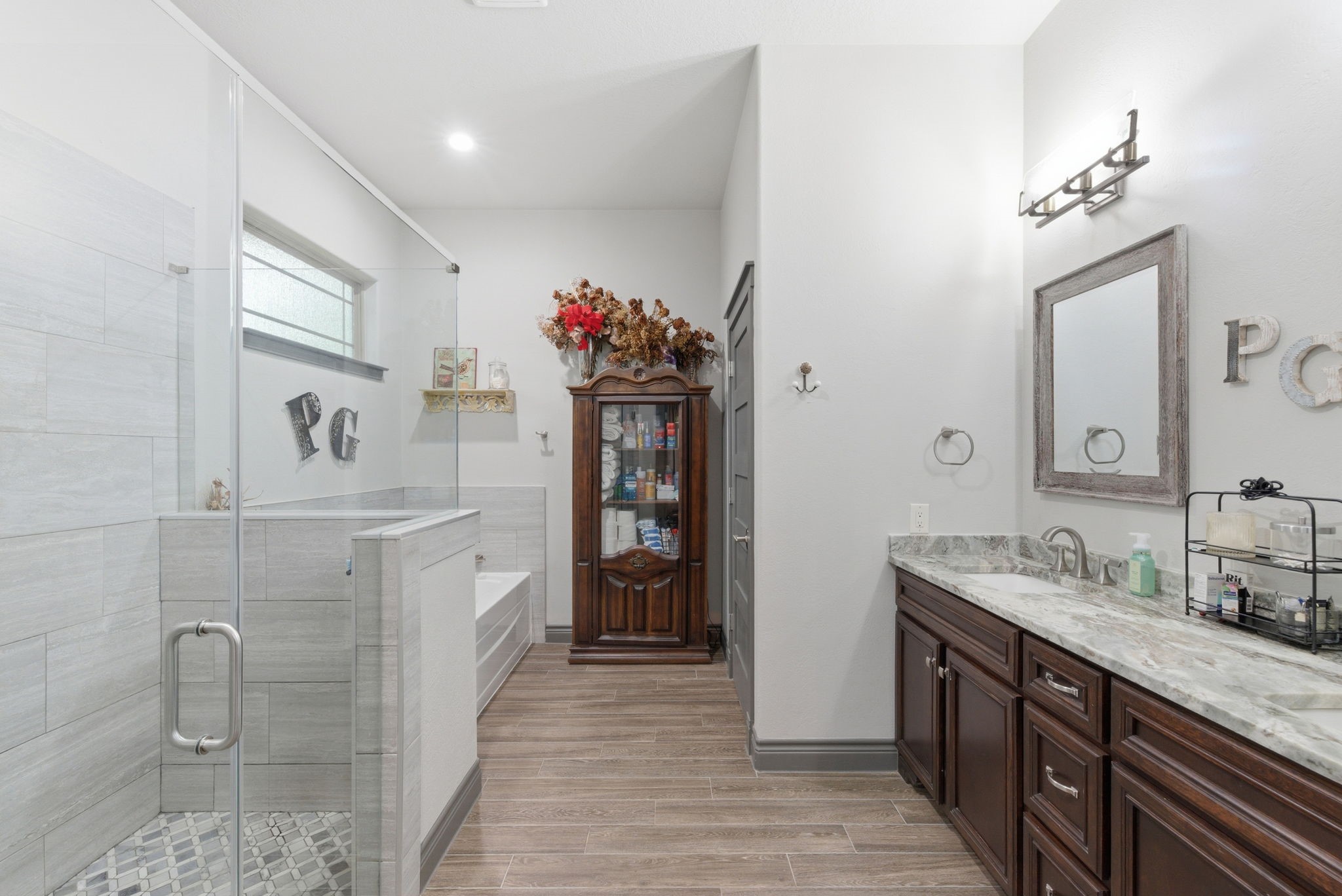1480 Traylor Road Conroe, TX 77304 - Photo 11 of 25 Spacious bathroom with dual vanity, stone countertops, walk-in shower, and wood flooring