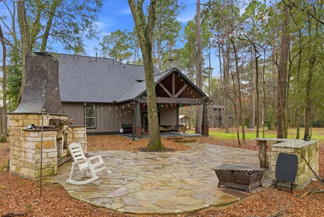 an aerial view of residential house with outdoor space and trees all around