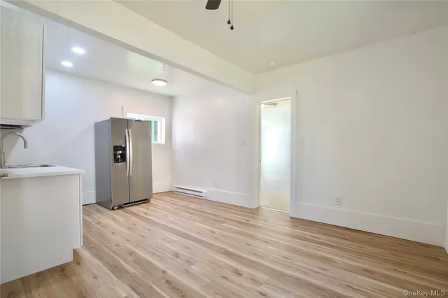 a kitchen with kitchen island white cabinets and wooden floor