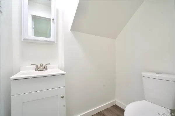 a bathroom with a granite countertop toilet sink and mirror