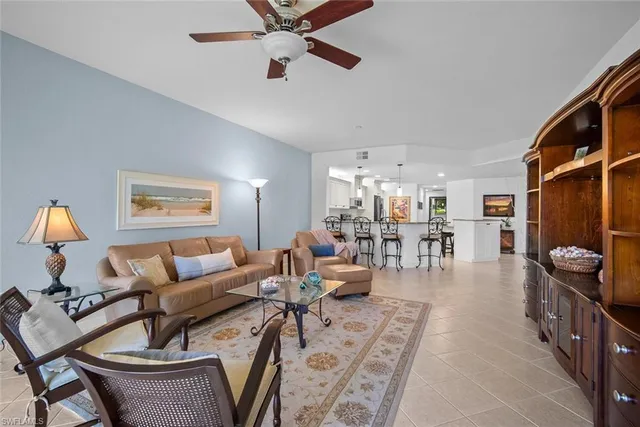 a living room with furniture a ceiling fan and a floor to ceiling window