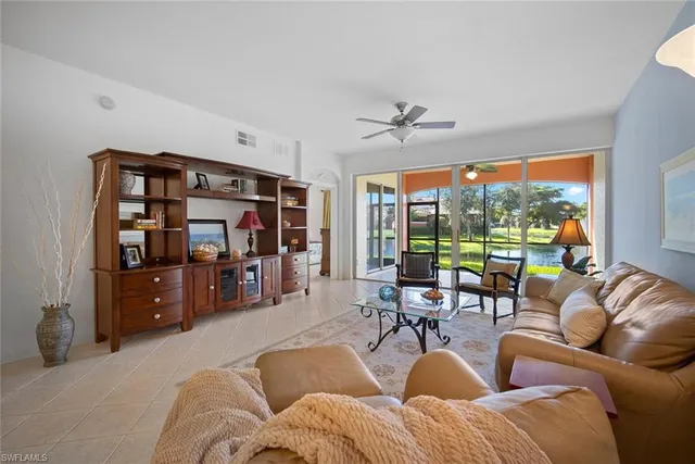 a living room with furniture a lamp and a large window