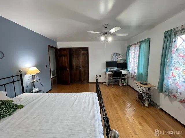 a bedroom with a bed and a flat tv screen on dresser