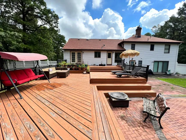 a view of a patio with table and chairs under an umbrella with wooden floor
