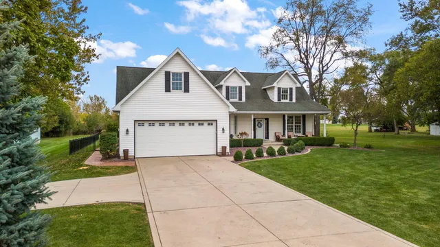 a front view of a house with yard and green space