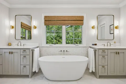 a spacious bathroom with a tub sink and mirror