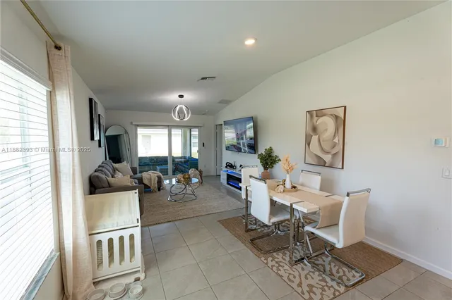 a dining room with furniture and a view of kitchen