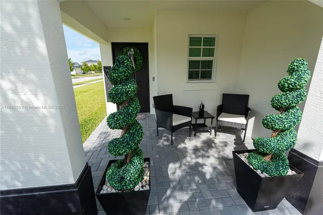a view of a porch with chairs and potted plants