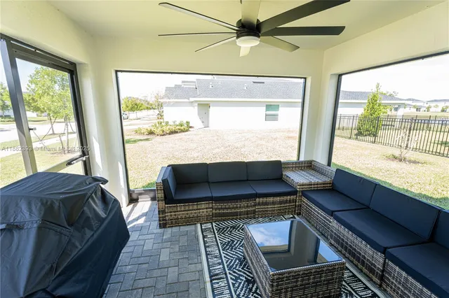 a living room with furniture and a floor to ceiling window