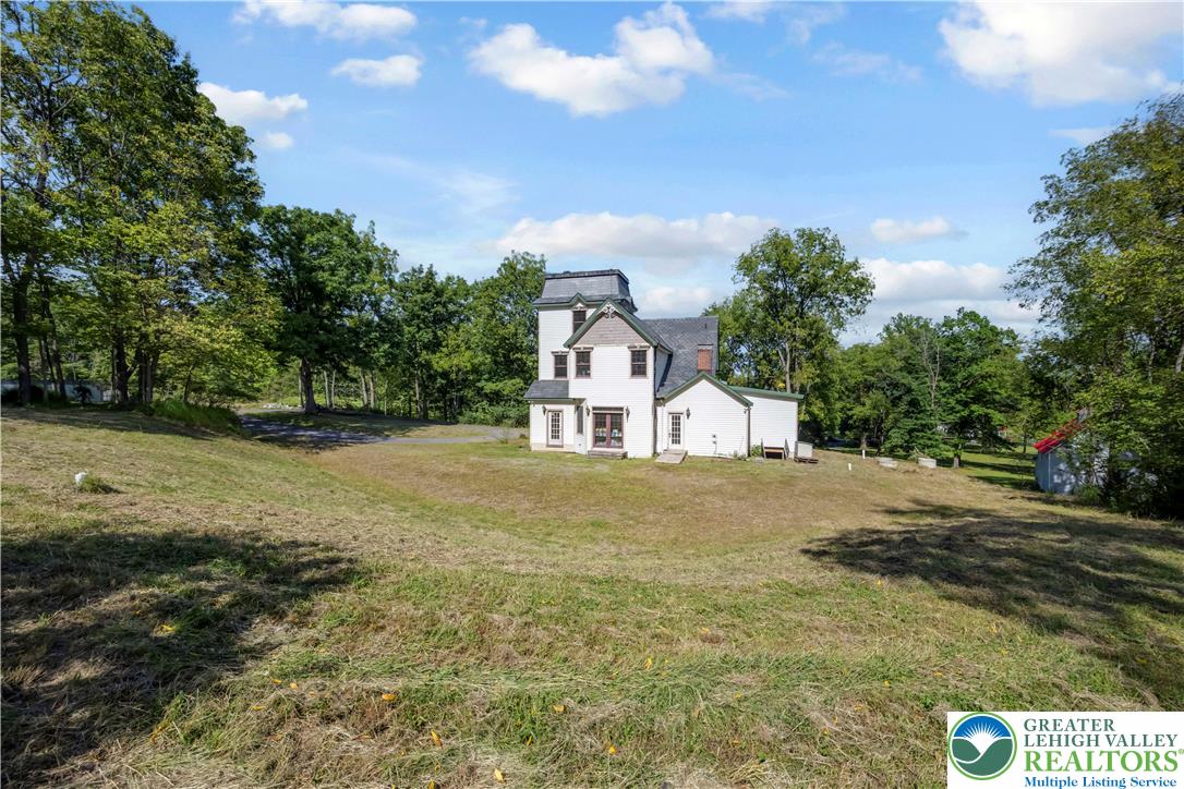 384 Henry Road Nazareth, PA 18064 - Photo 4 of 54 A historic multi-story home stands proudly surrounded by a vast grassy lawn and mature trees.