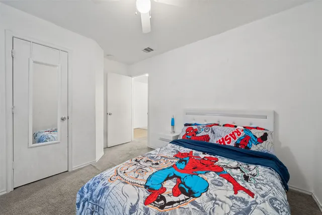 a bedroom with a bed that has a blanket and pillows