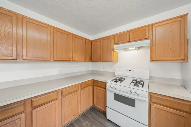 a kitchen with cabinets appliances a sink and a counter space