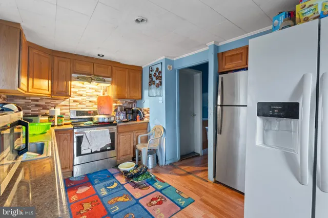 a kitchen with stainless steel appliances granite countertop a refrigerator and a stove top oven