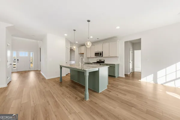 a large kitchen with cabinets wooden floor and stainless steel appliances
