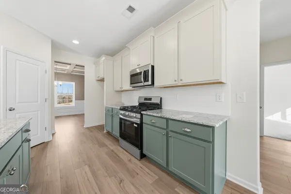 a kitchen with stainless steel appliances granite countertop a stove a sink and a refrigerator