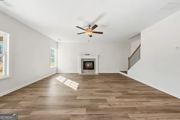 a view of an empty room with a fireplace and a window