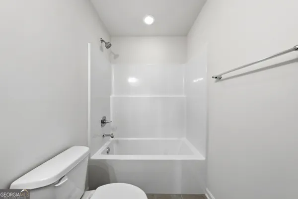 a bathroom with a toilet and a bath tub