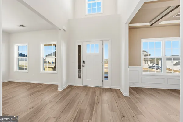 an empty room with wooden floor and windows