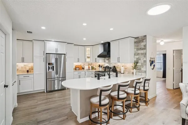 a kitchen with stainless steel appliances a refrigerator and a stove top oven