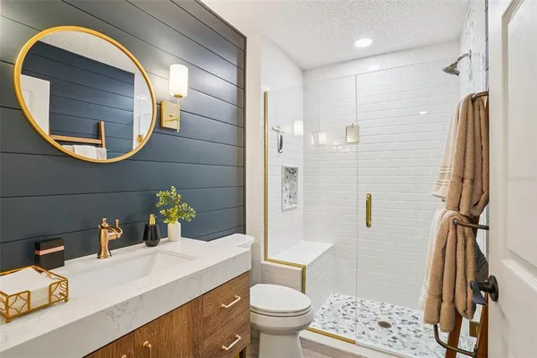 a bathroom with a sink and mirror with toilet
