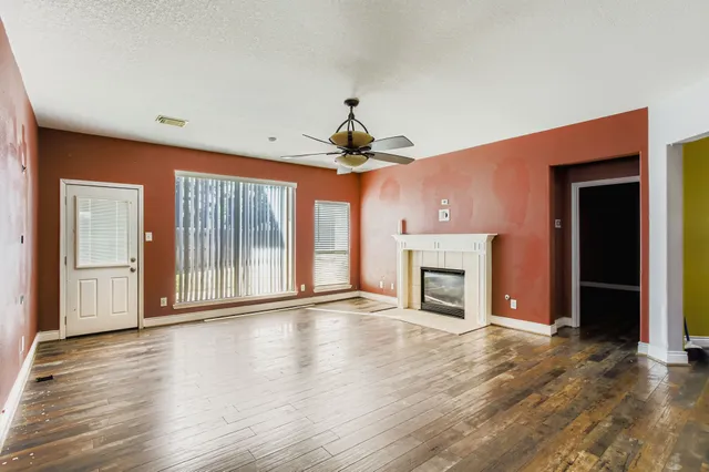 a view of an empty room with window and fire place