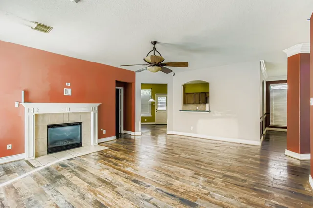 a view of a livingroom with wooden floor and a fireplace