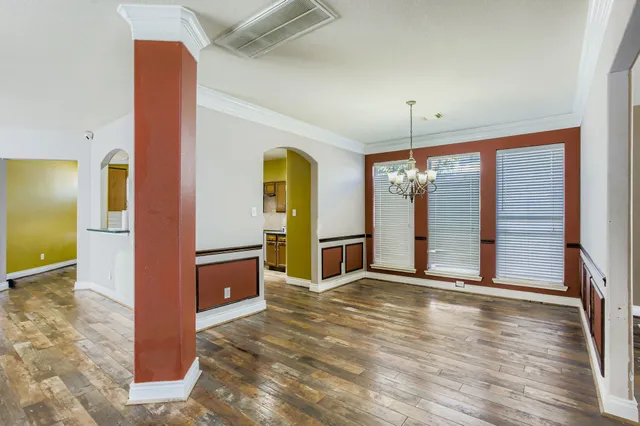 an empty room with kitchen and windows