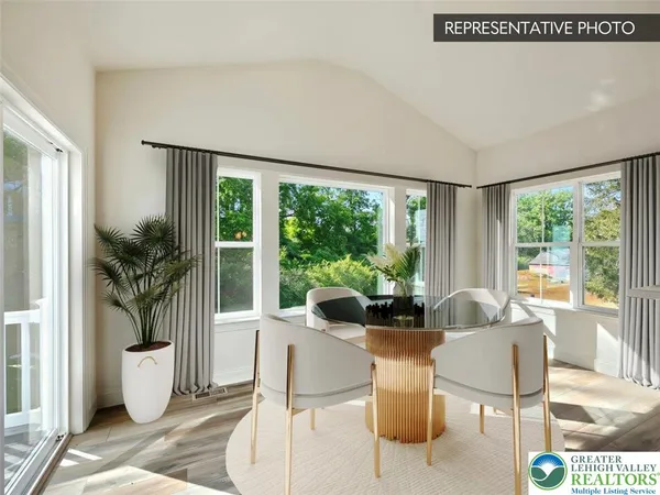 a dining room with furniture a large window and a potted plant