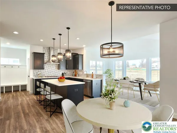 a view of a dining room and livingroom furniture wooden floor kitchen view and a chandelier