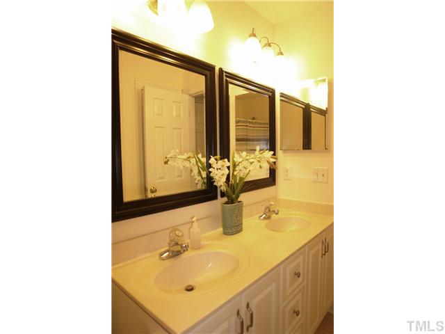 11612 Shavenrock Place Raleigh, NC 27613 - Photo 21 of 25 a bathroom with a sink and a mirror