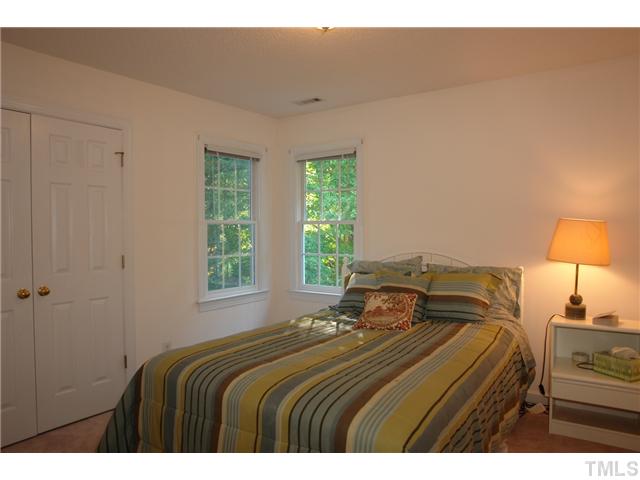 11612 Shavenrock Place Raleigh, NC 27613 - Photo 22 of 25 a bedroom with a bed and a lamp