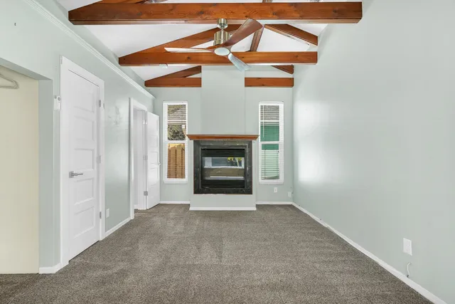 a view of an empty room with a fireplace and a window