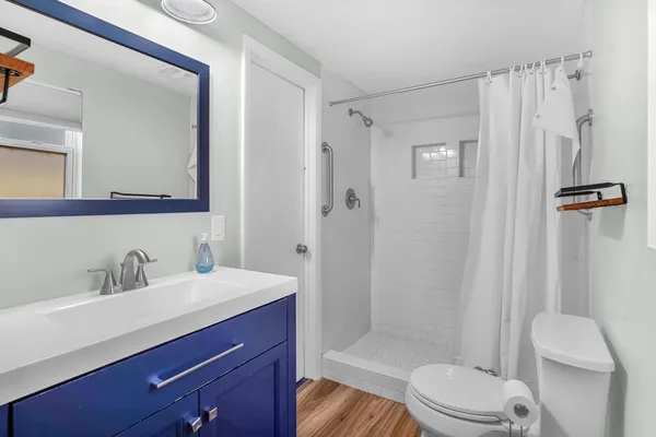 a bathroom with a sink a toilet and shower