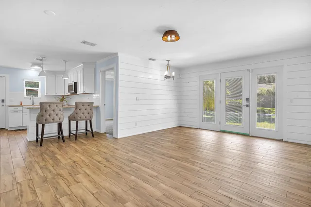 a view of an empty room with wooden floor and a fireplace