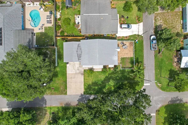 an aerial view of residential houses with outdoor space and trees