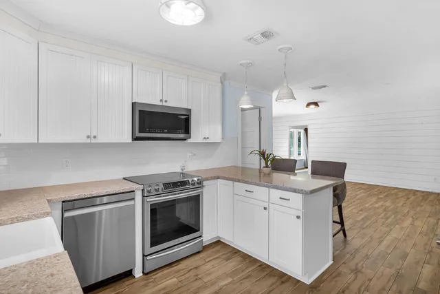 a kitchen with a sink stove and microwave