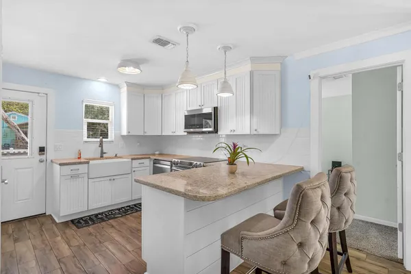 a kitchen with a sink cabinets and wooden floor