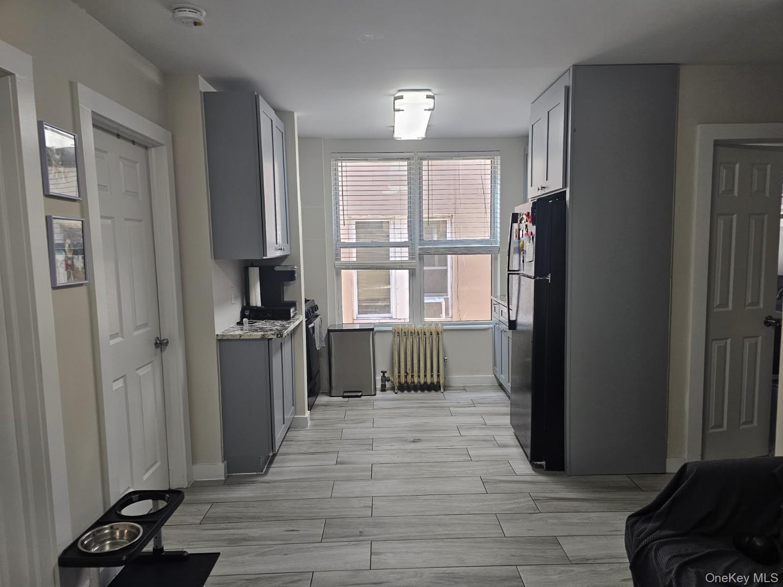 43-32 40th Street Queens, NY 11104 - Photo 11 of 14 a view of a refrigerator in kitchen and wooden floor