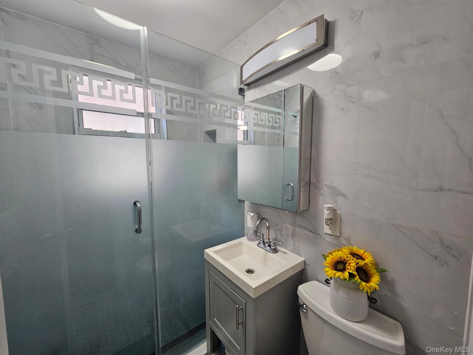 43-32 40th Street Queens, NY 11104 - Photo 6 of 14 a bathroom with a sink mirror toilet and vanity