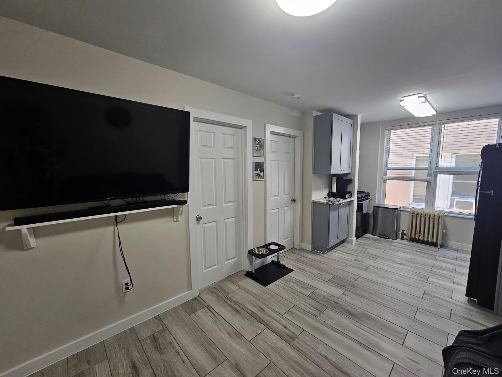 43-32 40th Street Queens, NY 11104 - Photo 7 of 14 a view of a livingroom with a flat screen tv wooden floor and windows