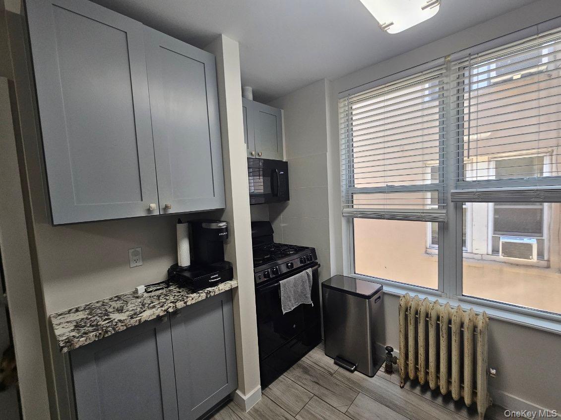 43-32 40th Street Queens, NY 11104 - Photo 9 of 14 a kitchen with granite countertop a stove and a refrigerator