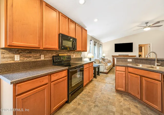 a kitchen with stainless steel appliances granite countertop a stove a sink and a microwave