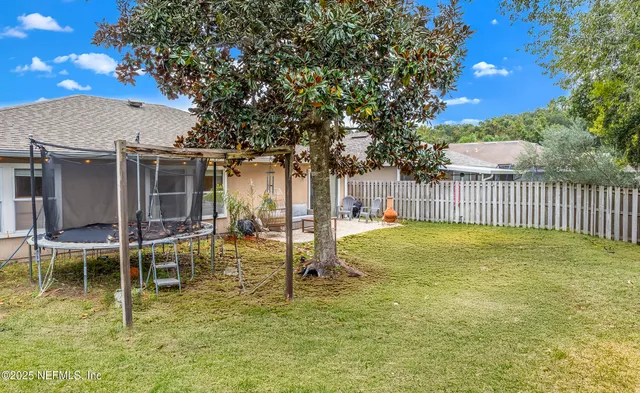 an aerial view of a residential houses with yard