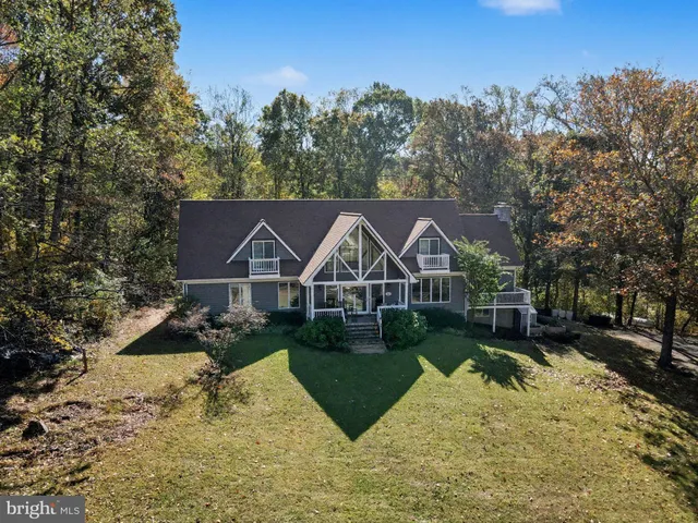 a view of a big house with wooden fence and a big yard