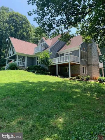 a front view of a house with a yard and trees