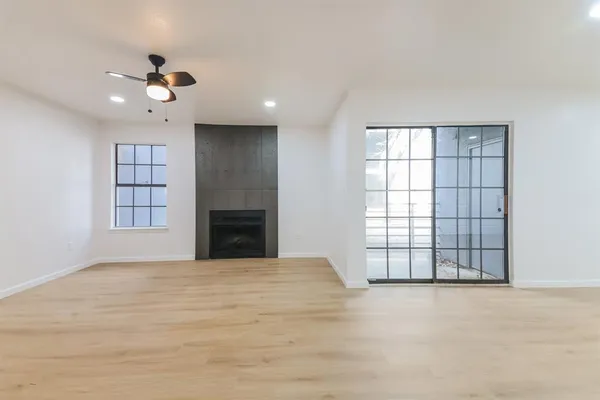 a view of an empty room with a fireplace and a window