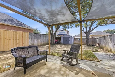 a view of a patio with a table chairs and a barbeque