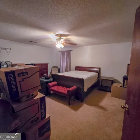 a spacious bedroom with a bed and a chandelier
