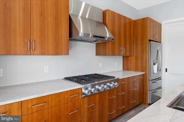 a large kitchen with stainless steel appliances granite countertop a lot of counter space and a wooden floors